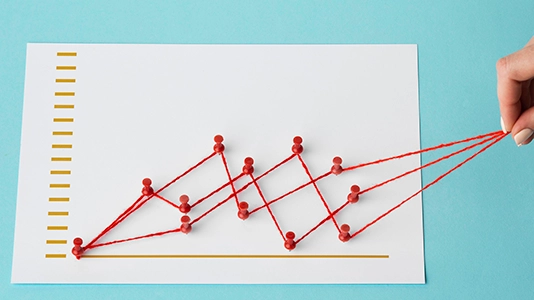 Hand pulling red string to lift a rising line chart made of pins, symbolizing higher Google Ads CTR
