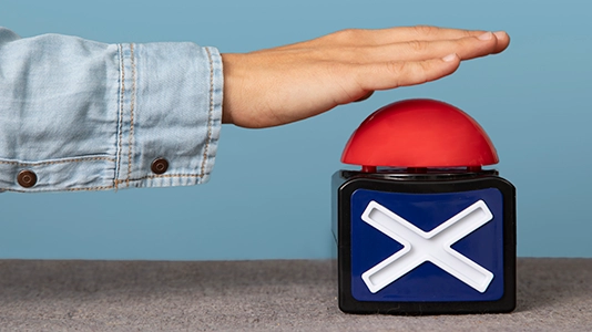 A hand reaching toward a large red button with a cross symbol, representing the decision to stop or reject an ad campaign