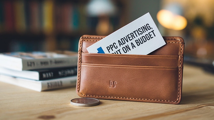 A leather wallet with a card labeled PPC Advertising But On A Budget representing the idea that small ad budgets can still deliver strong PPC results